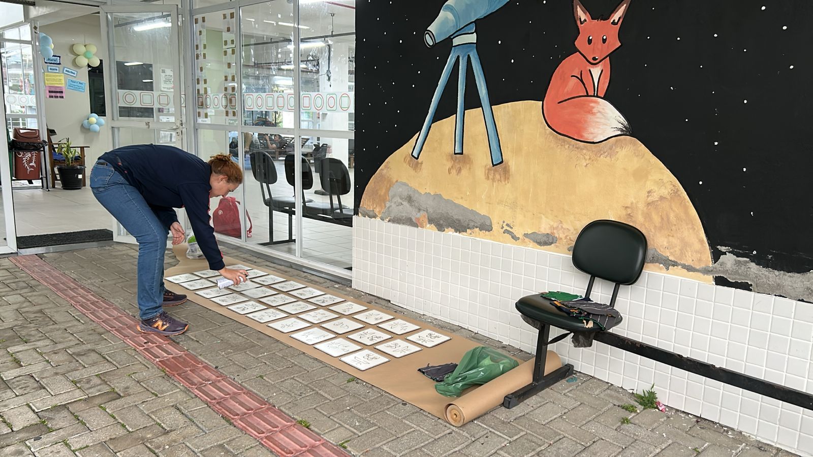 Servidora do Câmpus Palhoça Bilíngue finalizando o material para afixação nos espaços