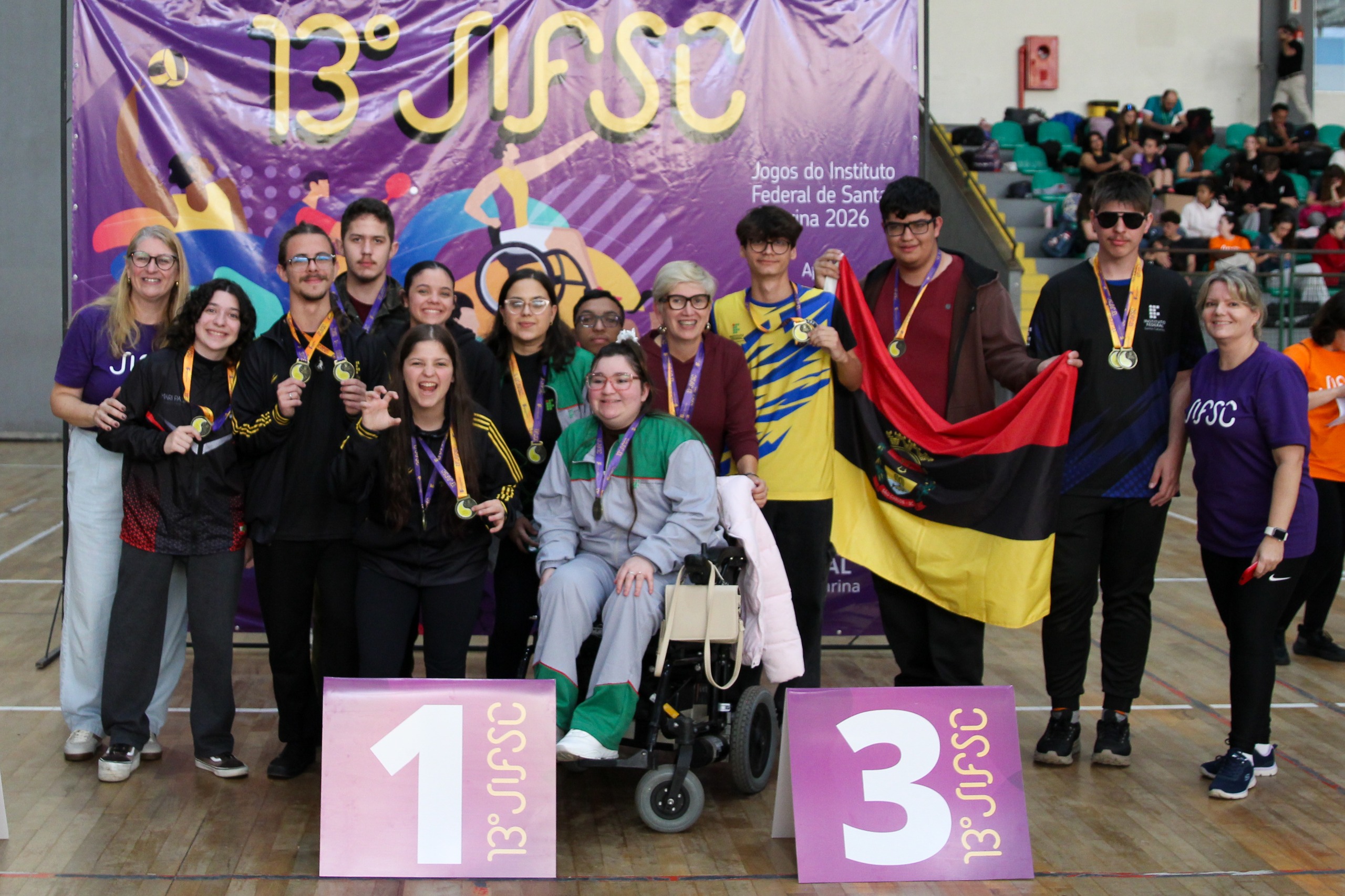 Atletas comemoram com medalhas no peito.