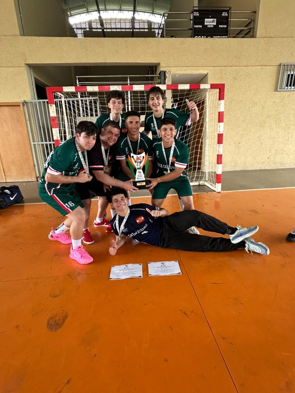 Turma vencedora comemorando com o Troféu JIF 2026 na mão