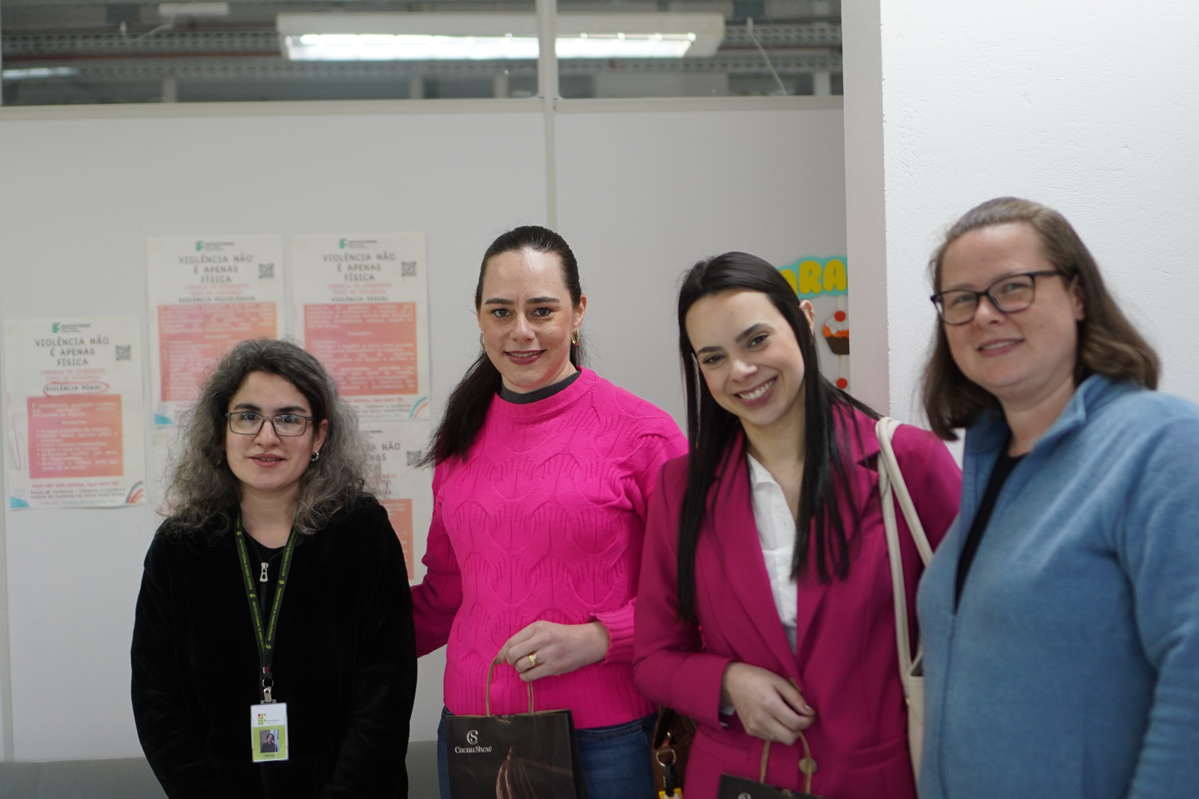 A enfermeira Dayane Bordin e a médica Ana Caroline Medeiros da Silva (centro) são recebidas pelas servidoras Vanessa Irizaga Lucrecio (esq) e Andreia Willrich (dir) durante o evento do Outubro Rosa no IFSC Câmpus Lages.